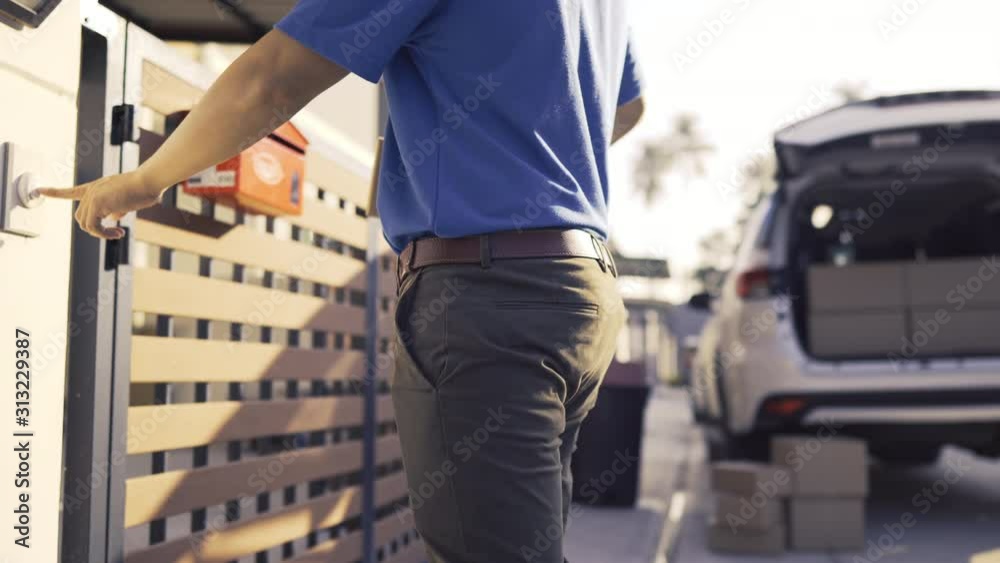 Delivery man sending parcel postal package order comes to customer at front house the open doorway, Delivery package service his smiling happy. Shot on 4K UHD Footage cinematic 