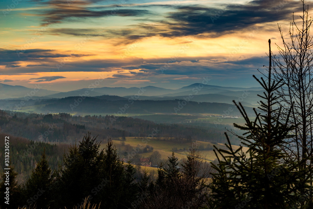 Sunset over hilly landscape of Sumava National Park, meadows and forests in Czech Republic, Central Europe.