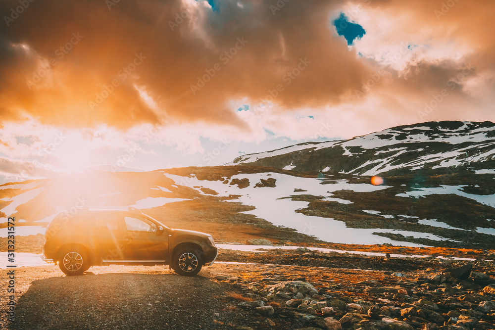 Aurlandsfjellet, Norway. Car SUV Parked Near Aurlandsfjellet Scenic Route Road In Summer Norwegian Landscape. Popular Destination In Sunset Lights - obrazy, fototapety, plakaty 
