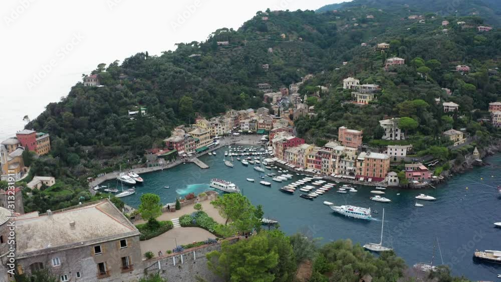 Aerial shot of Portofino, famous picturesque harbour with luxurious Yachts, Castello Brown in foreground - Genoa, Italy, Europe, sunny summer day Aerial shot of Portofino, famous picturesque harbour with luxurious Yachts, Castello Brown in foreground - Genoa, Italy, Europe, sunny summer day