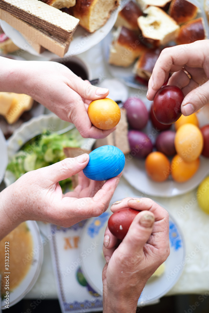 The family holds Easter eggs in their hands for the Easter breakfast The family holds Easter eggs in their hands for the Easter breakfast