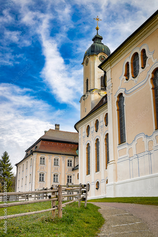 Wieskirche Pilgrimage Church with clody blue sky and green lawn  in Bavaria, Germany.