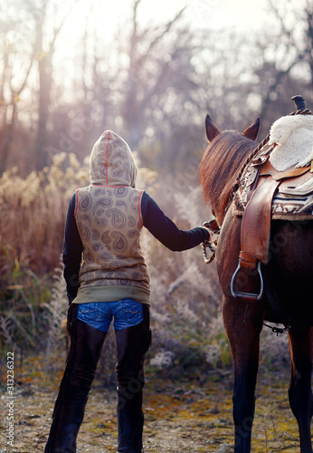 Young beautiful dreadded girl outdoors with her horse.