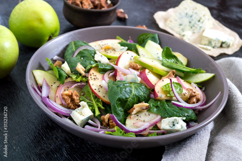 Tasty diet fitness salad with spinach, apples, red onions, blue cheese, nuts. Proper nutrition.