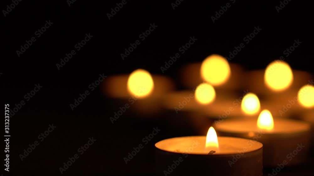 Slow motion white candles light up flames fire on isolated black background. Use in romantic dinner, warm and relax peace maditaion, use for spiritual religion church decotion and Halloween graveyard