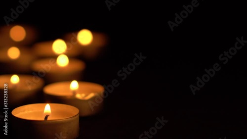 Slow motion white candles light up flames fire on isolated black background. Use in romantic dinner, warm and relax peace maditaion, use for spiritual religion church decotion and Halloween graveyard