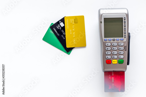 Pay by card. Plastic card inserted in terminal on white background top-down copy space