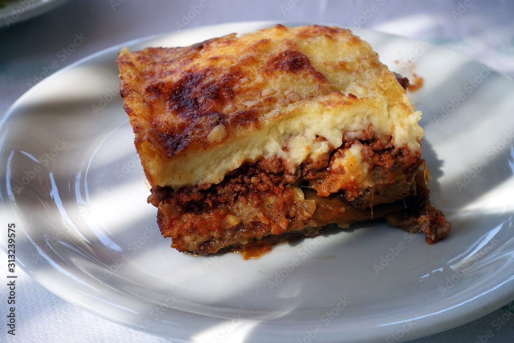 moussaka with aubergine on a dish. traditional greek meal on a table moussaka with aubergine on a dish. traditional greek meal on a table