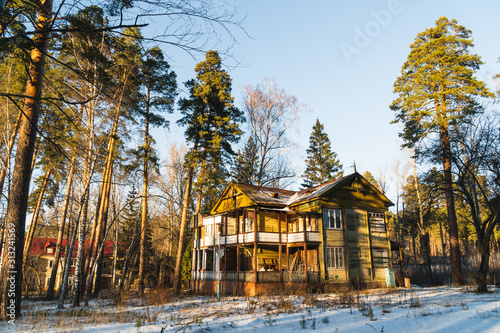 Fotografie, Tablou an old abandoned house in a pine winter forest