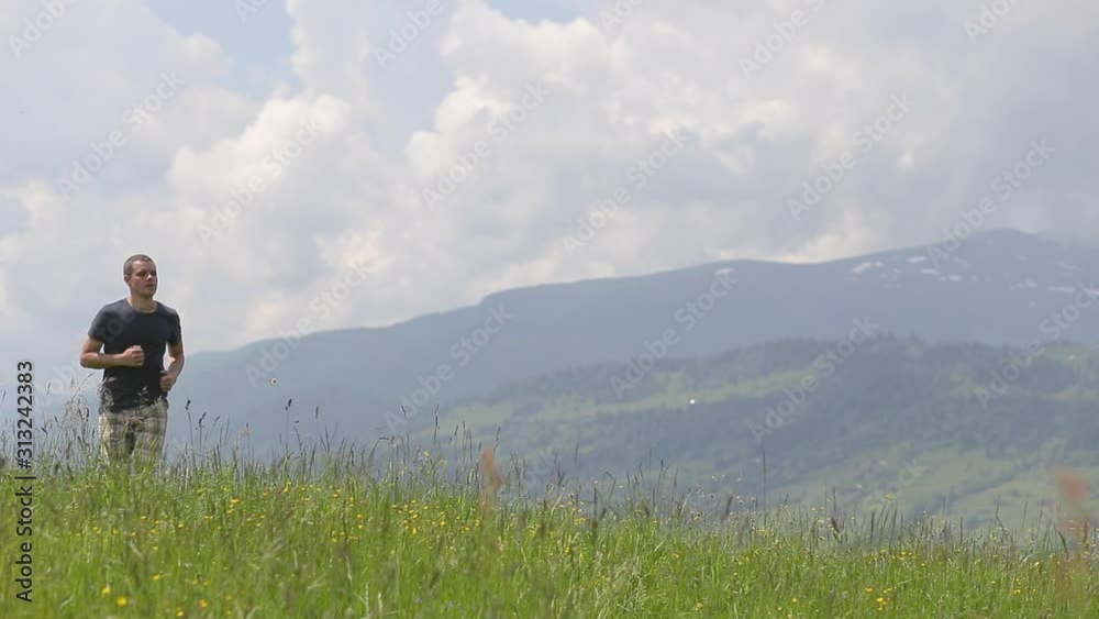 Young man tourist raising his hands in winner gestion while hiking in summer mountains. Young man tourist raising his hands in winner gestion while hiking in summer mountains.