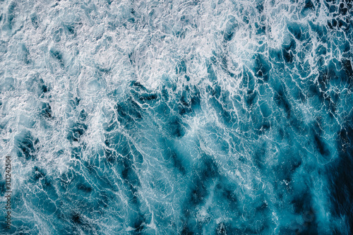 Aerial view to seething waves with foam. Waves of the sea meet each other during high tide and low tide.