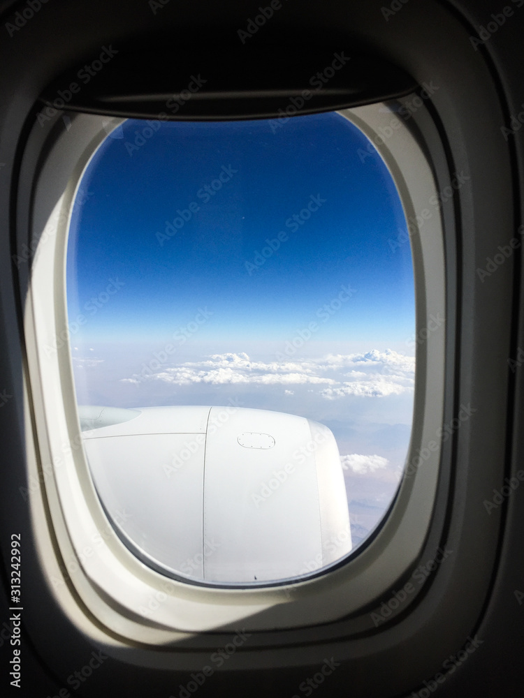 Fototapeta premium Airplane window with blue sky background