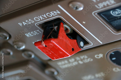 Sealed and secured red Passenger Masks and Oxygen Control switch on the Flight Deck of a Jumbo Jet photo