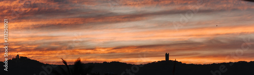 Panaromic shot of the orange clouds above the hills during sunset in Wankaner, Gujarat, India