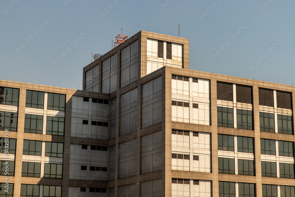 Abstract images of geometric shapes on buildings with repeating structure and reflected sky.