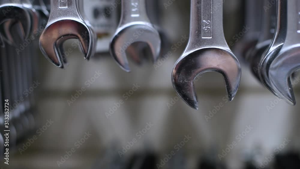 wrenches of different sizes hang on a store stand. The camera moves along the wrenches