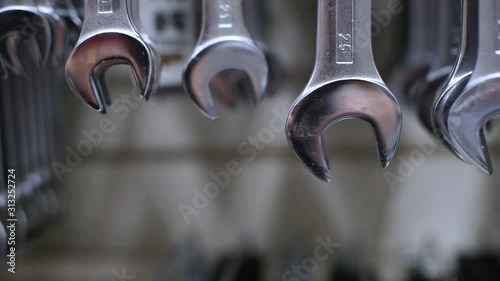 wrenches of different sizes hang on a store stand. The camera moves along the wrenches