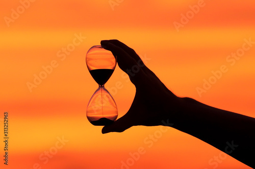 Hourglass in hand at sunset.