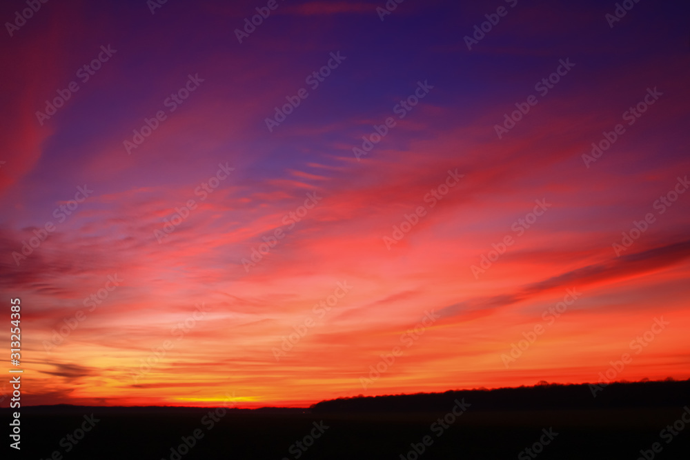 Very colorful clouds in dramatic sky. Romantic sunset at the countryside.