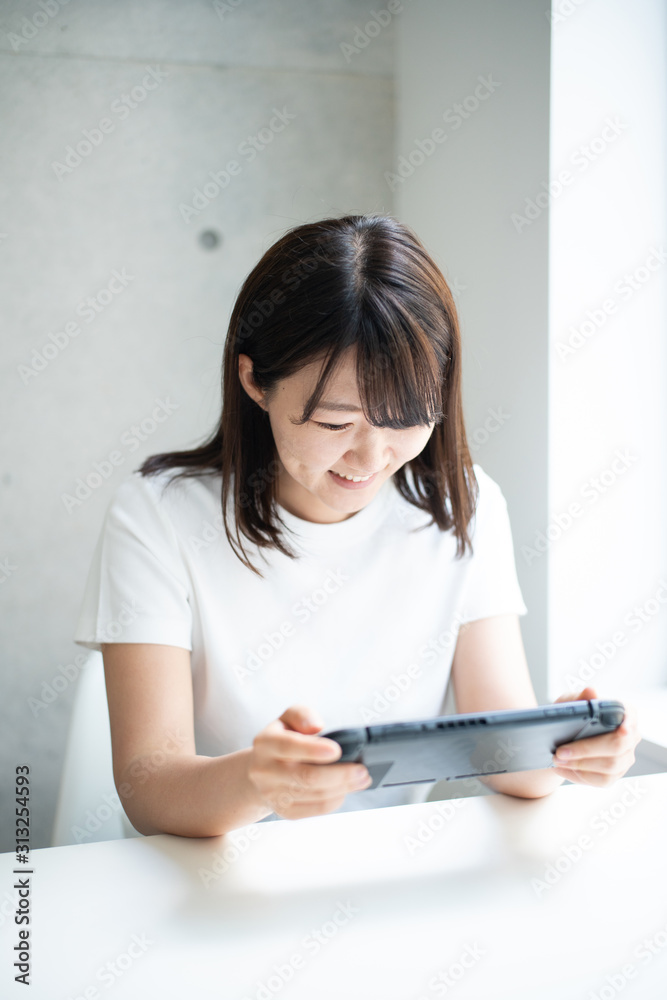携帯ゲームで遊ぶ女性 携帯ゲームで遊ぶ女性