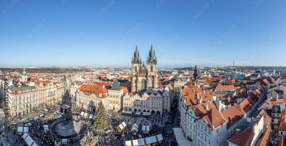 Old Town of Prague, Czech Republic. View on Tyn Church and Jan Hus Memorial on the square as seen from Old Town City Hall during Christmas market. Blue sunny sky