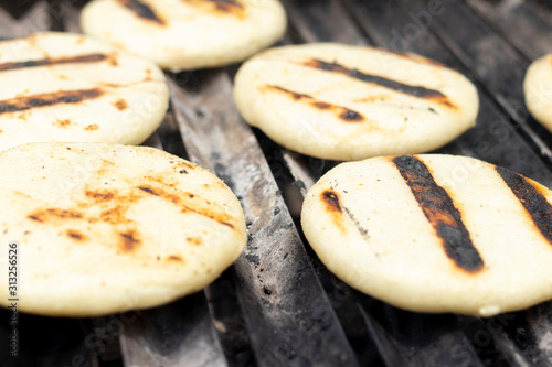 Toasted arepas cooking on the grill