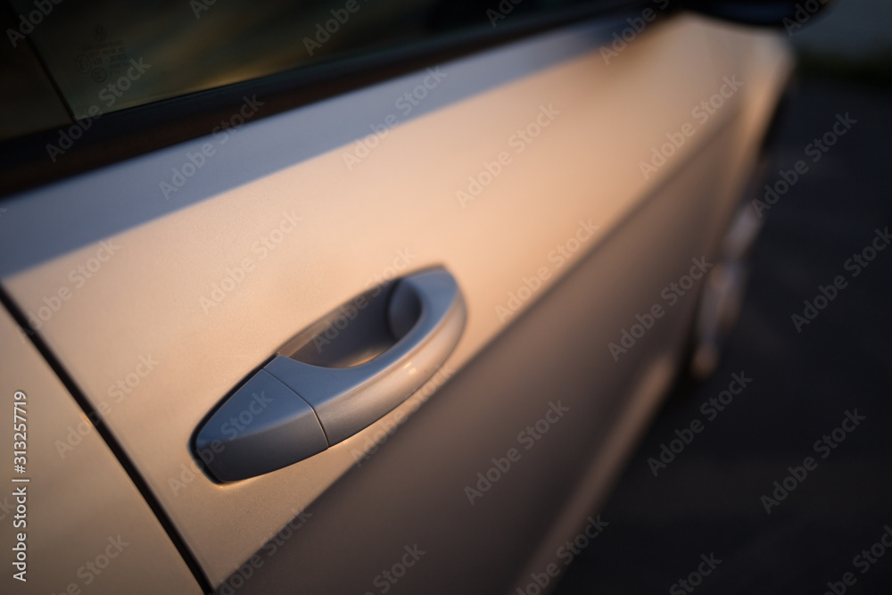 Modern car outside door handle at the sunset