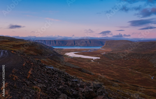 Patreksfjordur at sunset, Vesturland, Iceland - september 2019: Country road in the impressive fjord landscape or the Westfjords in Iceland photo