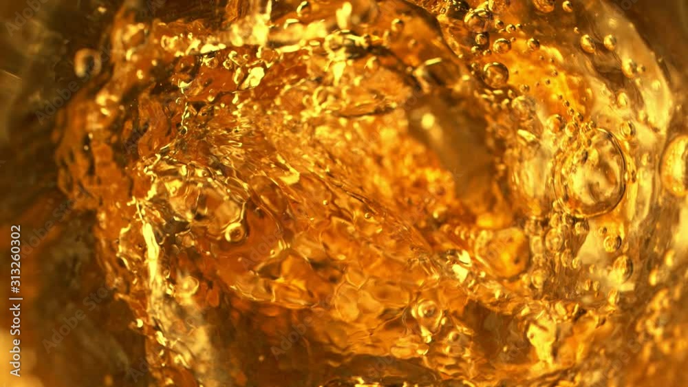Super slow motion of pouring whiskey, rum or cognac inside the bottle, macro shot. Filmed on high speed cinema camera, 1000fps