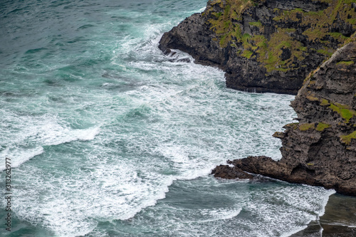 View of ocean waves entering rocky bay