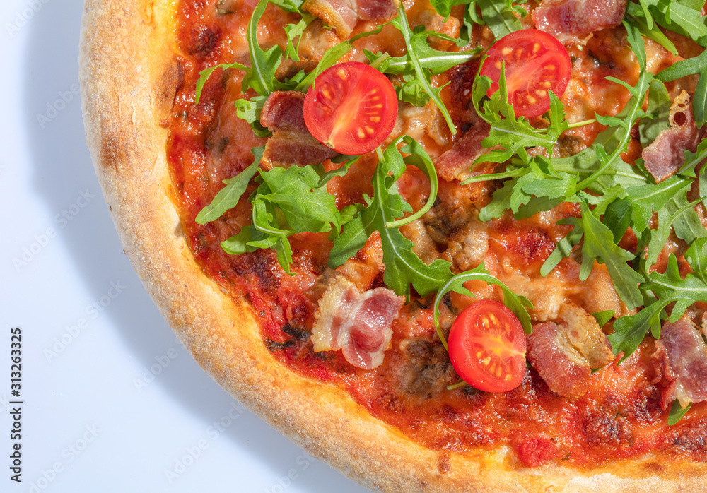 Italian hot pizza with tomato, arugula and pieces of bасon isolated on white background