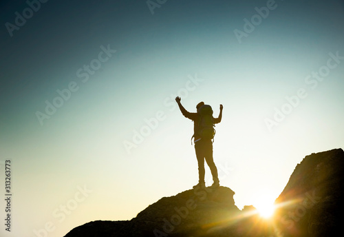Man with arms raised at sunset