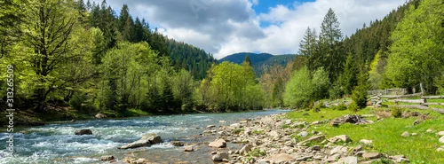Panel kuchenny z motywem river in mountains. wonderful springtime scenery of carpathian countryside. blue green water among forest and rocky shore. wooden fence on the river bank. sunny day with clouds on the sky