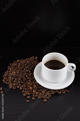 cup of coffee with coffee seeds on a black background