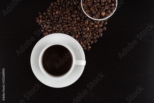 cup of coffee with coffee seeds on a black background