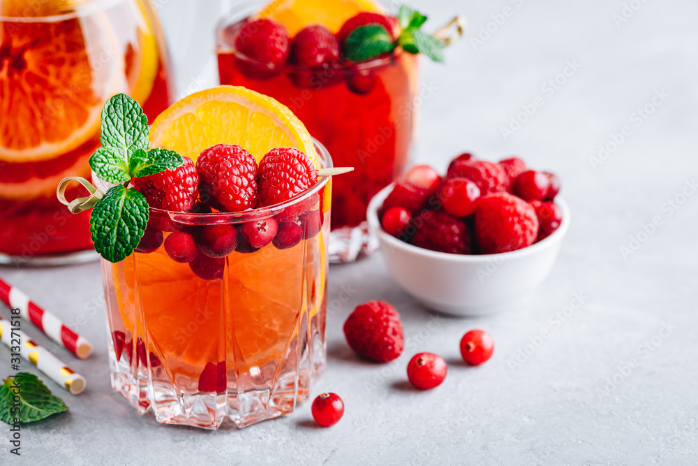 Raspberry Cranberry Sangria Punch or Mojito in glass with orange slices and mint Raspberry Cranberry Sangria Punch or Mojito in glass with orange slices and mint