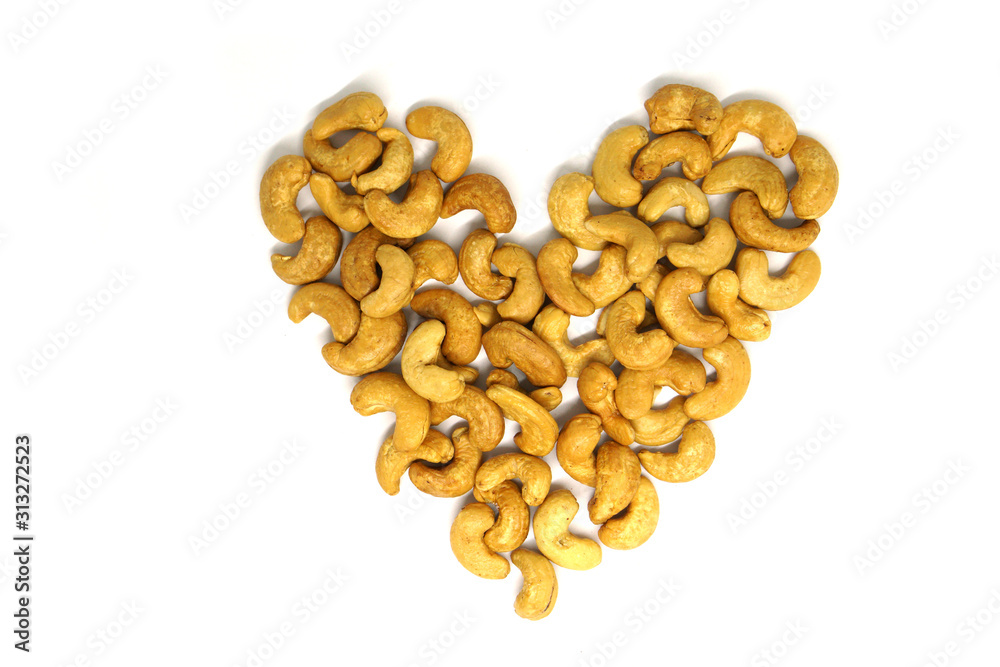 Obraz premium Cashew nut group heart pattern isolated white background - healthy nutrients food for heart concept