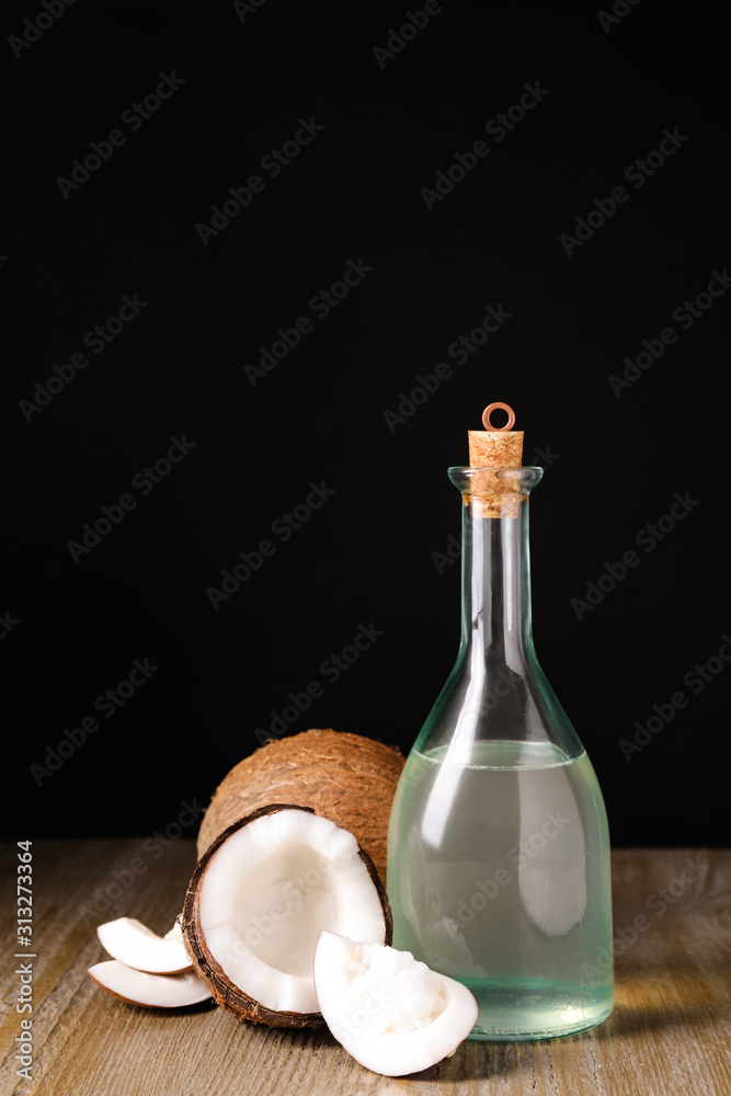 Coconut oil on wooden table against black background Coconut oil on wooden table against black background