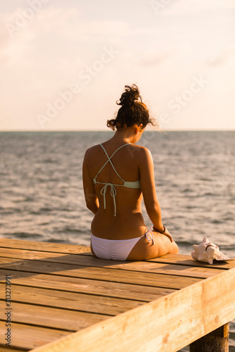 Young female in bikini at beach on wharf