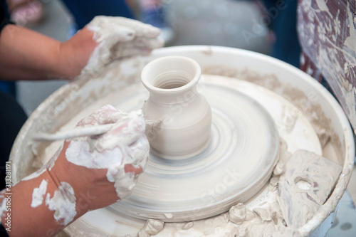 The potter makes pottery dishes on potter's wheel. © Pavlo Burdyak