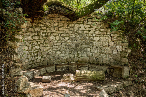 Place to rest and reflect. Beautiful warm spring day and archeological ruins at Butrint National Park, Albania, UNESCO heritage. Travel photography with fresh green flora and clear blue sky