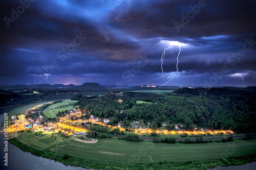 Storm front at night over an inhabited small village in elbe sandstone mountains
