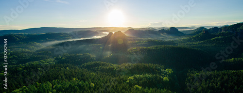 Beautiful misty forests and rocks at sunrise in the Elbe Sandstone Mountain