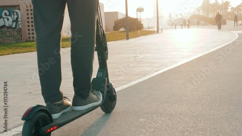 e-scooter rider, man ride sharing or rent personal eco transportation. man hipster riding an electric scooter road to work the modern way. Fast speed driving electric transport, day light