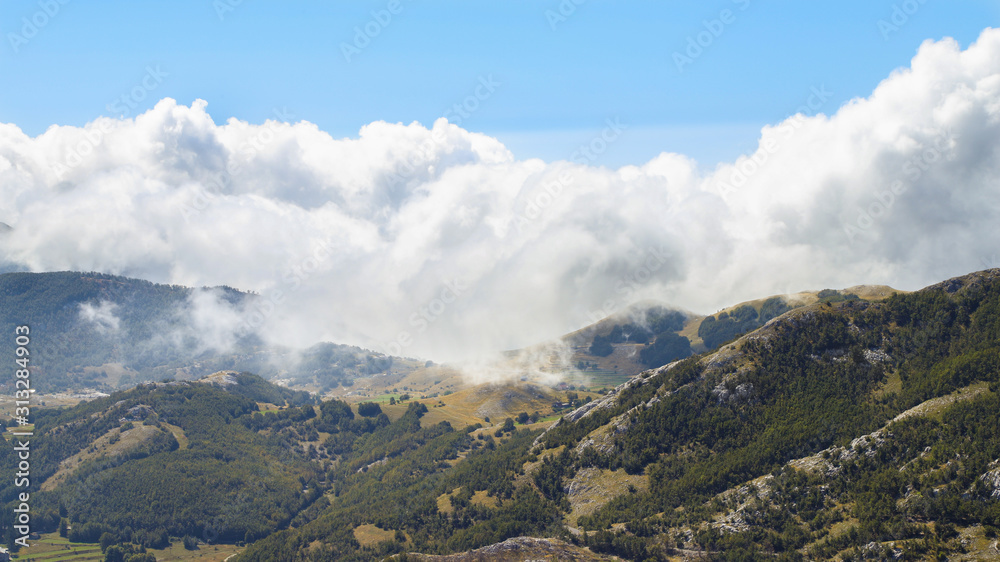 Nature of Montenegro. Clouds floating on mountains and forest.