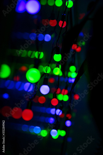 Multi-colored glare from garlands in the form of abstraction in the dark