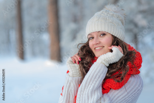 beautiful girl in winter forest in the snow smiling looking at the frame © Ermolaeva Olga
