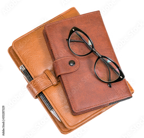 notebooks glasses and pen on a white background