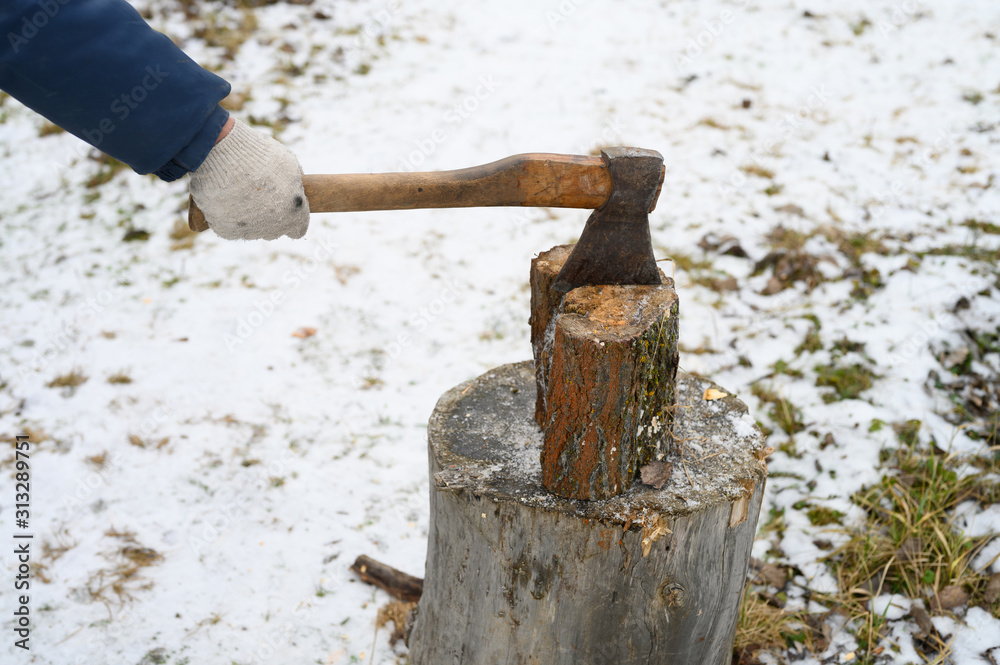 man's hand with an axe chopping wood man's hand with an axe chopping wood