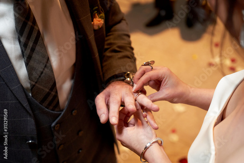 Bride Dresses the Ring for the Groom, close-up in marriage registry office
